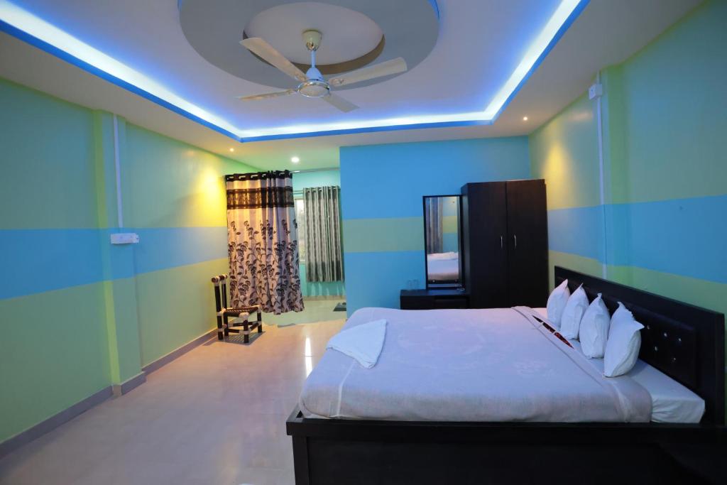 een slaapkamer met een bed en een plafondventilator bij The PugMark Wildlife Resort in Jyoti Gaon
