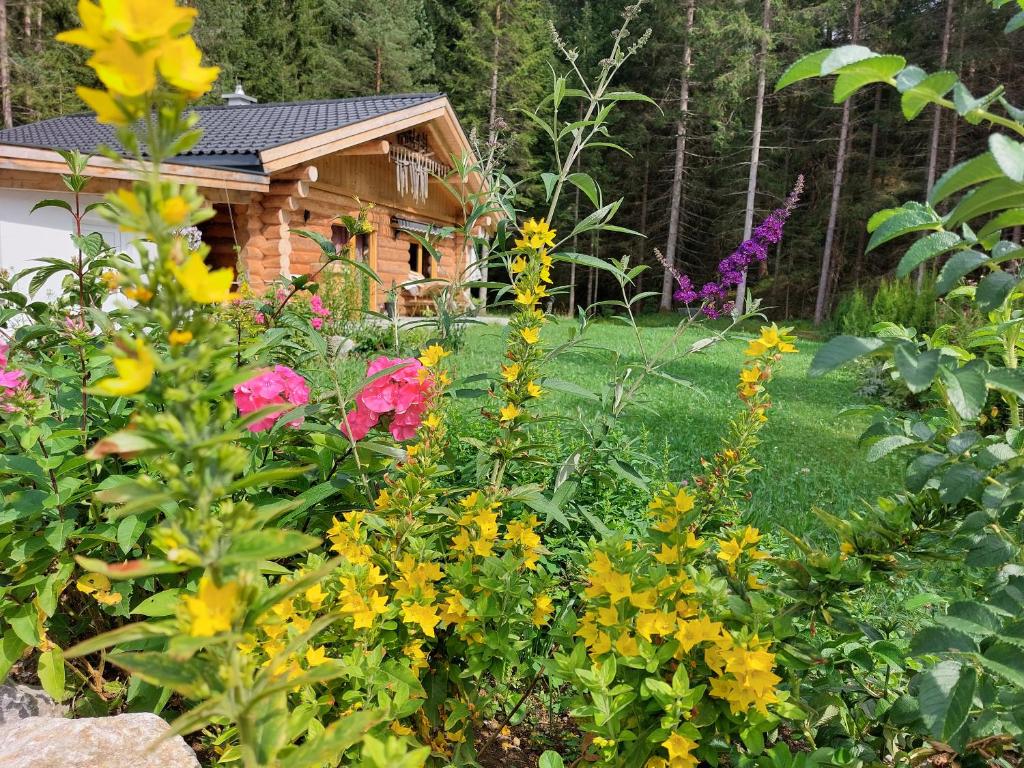 a garden with flowers in front of a cabin at Ferienhaus - Chalet - Lechtraum in Stanzach