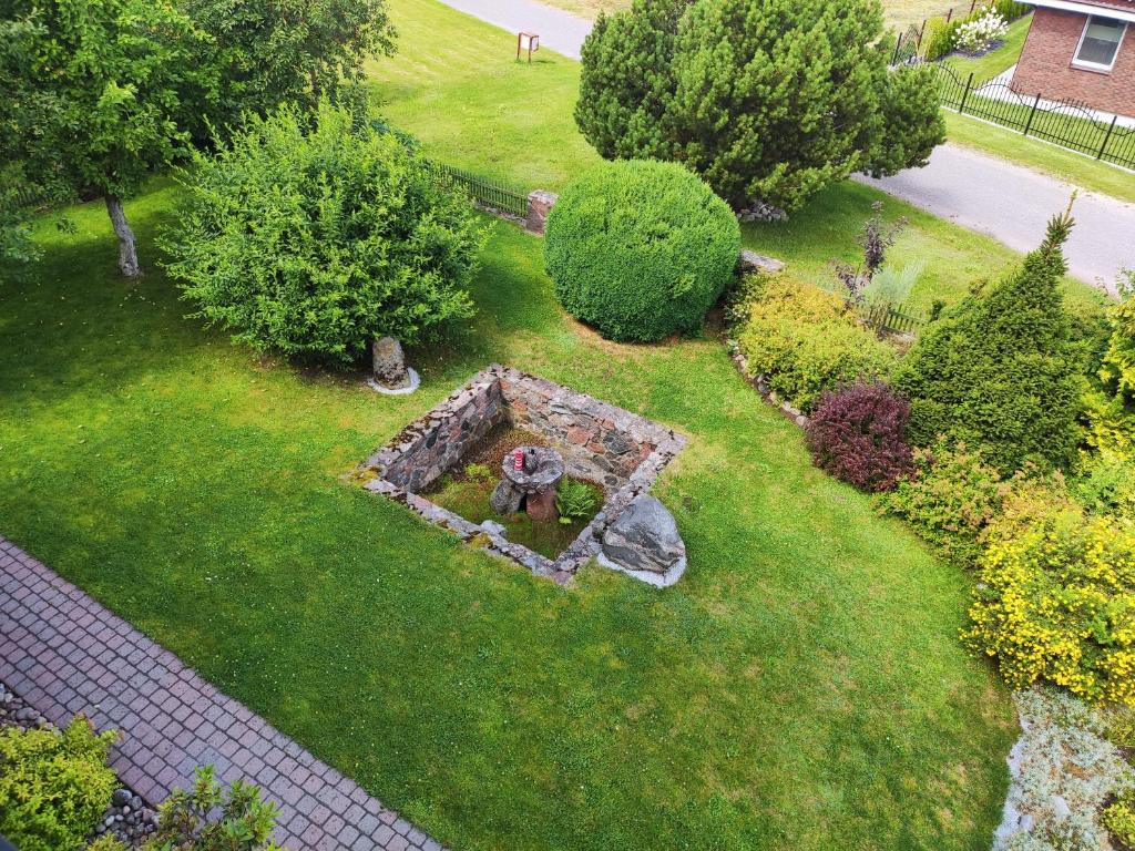 an aerial view of a garden with a stone structure at Spacious & Cozy Apartment with Forest View in Zapyškis