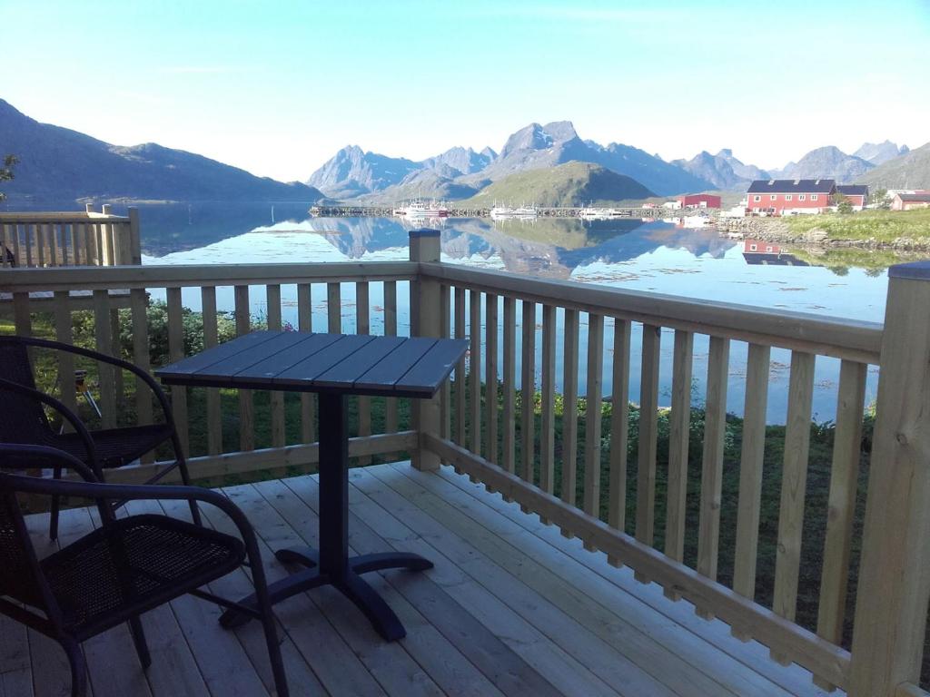 una mesa y sillas en una terraza con vistas al lago en Fredvang Seahouse, apartment A, en Fredvang