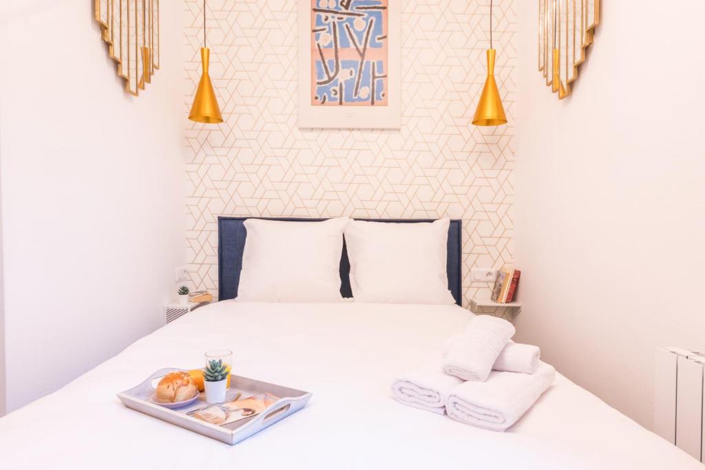 Un dormitorio con una cama con una bandeja de comida. en Apartments WS Tour Eiffel - Laos en París