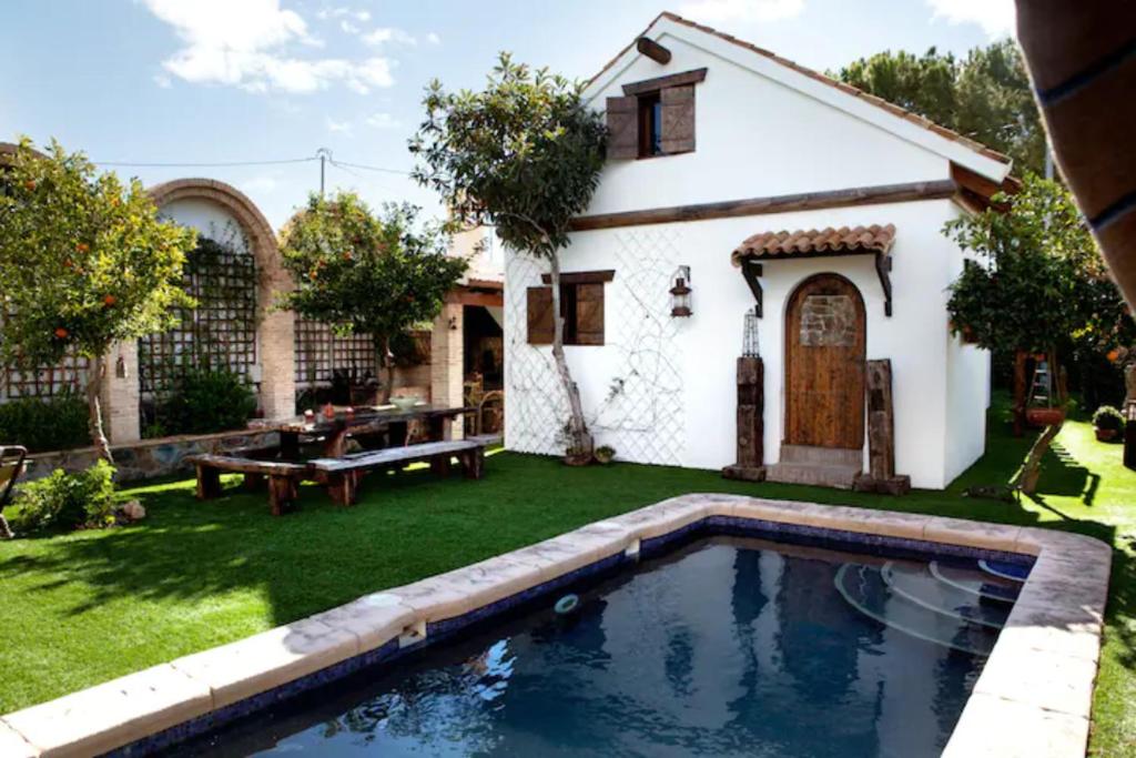 a backyard with a pool and a house at El vergel encantado in La Ñora