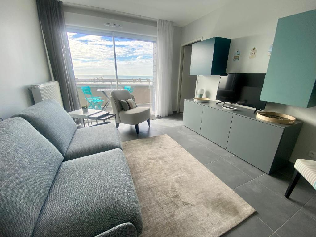 uma sala de estar com um sofá e uma cozinha com vista em Appartement de standing VUE MER em Berck-sur-Mer