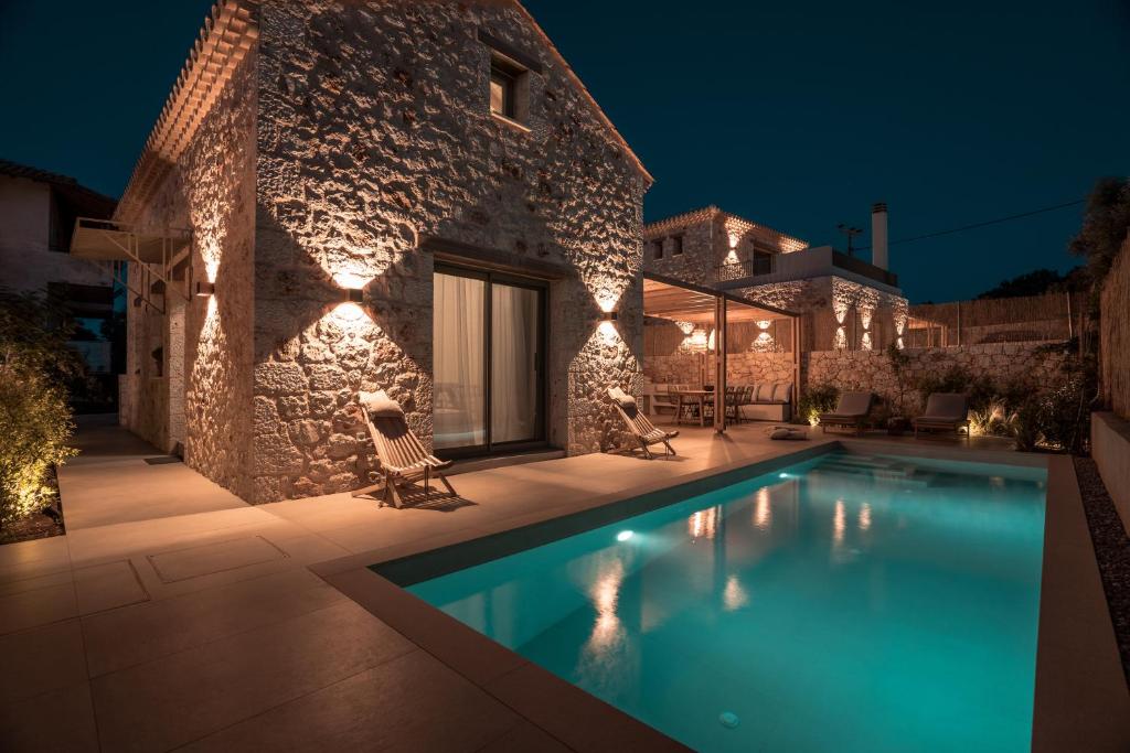 a villa with a swimming pool at night at PAPADRIA VILLAS - Modern Luxury villas near Kathisma Beach in Tsoukaladhes