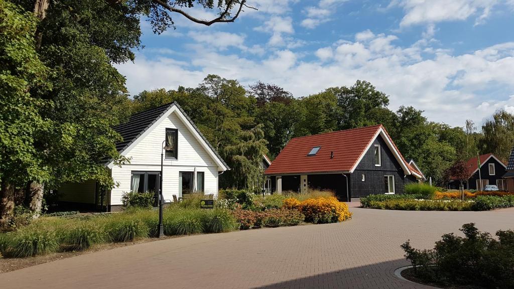 une maison blanche et une maison noire avec un toit rouge dans l'établissement Villapark Ehzerburg, à Almen
