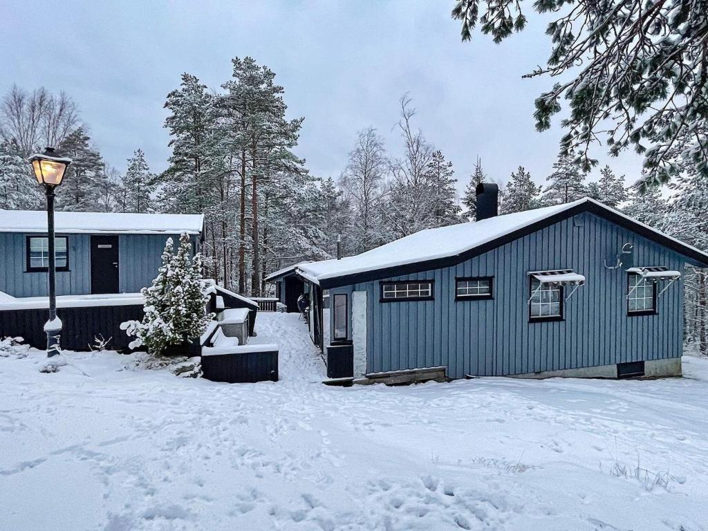 een klein blauw gebouw in de sneeuw met een straatlantaarn bij 10 person holiday home in Halden-By Traum in Halden