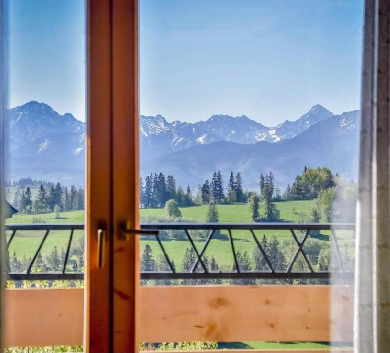 an open door with a view of a mountain range at Atlas Chmur Apartament in Biały Dunajec