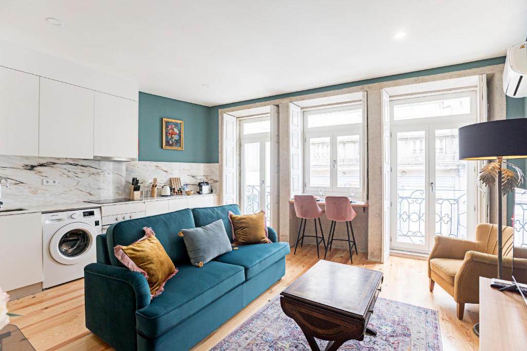 salon z niebieską kanapą i kuchnią w obiekcie Turquoise Central Flat w AC & Balcony by LovelyStay w Porto
