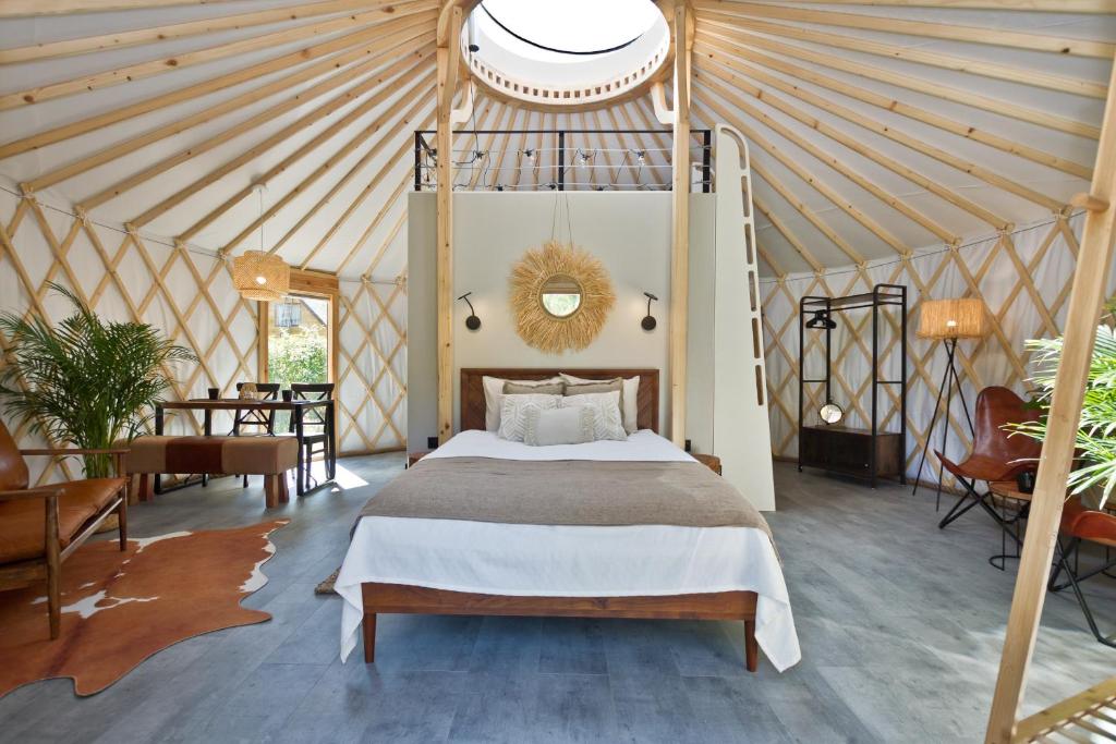 a bedroom with a bed in a tent at JURTLANDIA jurta LOFT in Lubiatowo