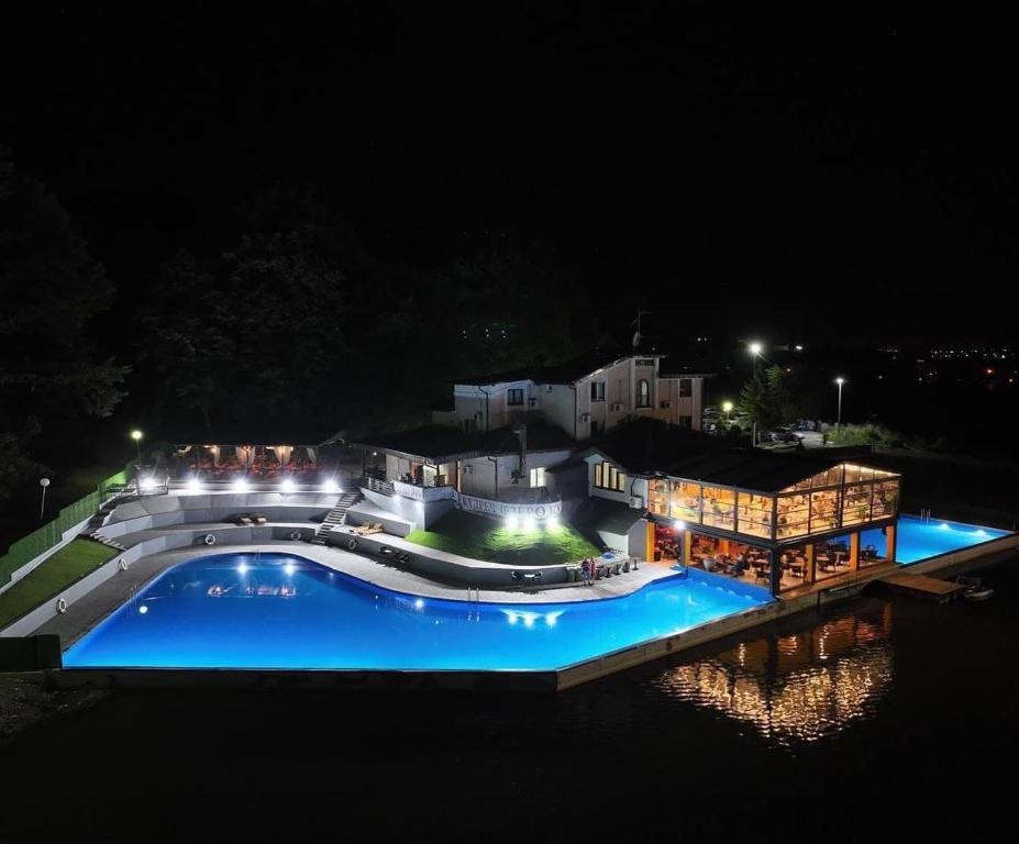 Smederevska Palanka的住宿－Jezero Kudrec，一座晚上设有游泳池的房子