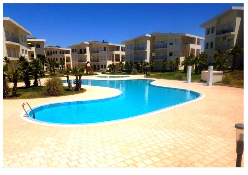a large swimming pool in front of some apartment buildings at Mehdia plage in Kenitra