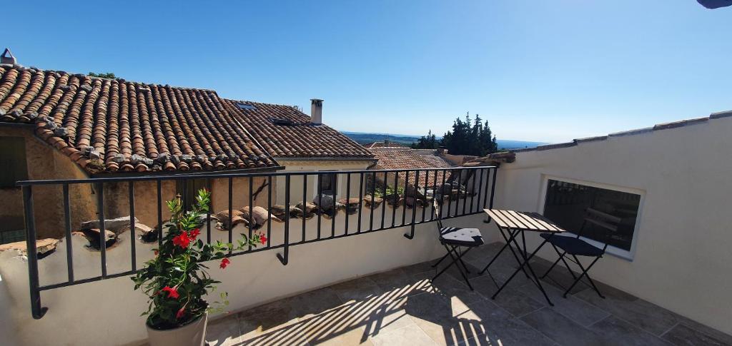 einen Balkon mit Stühlen und einem Tisch auf einem Gebäude in der Unterkunft La Carriera, petite maison sud Ventoux, au charme Provençal in Bédoin