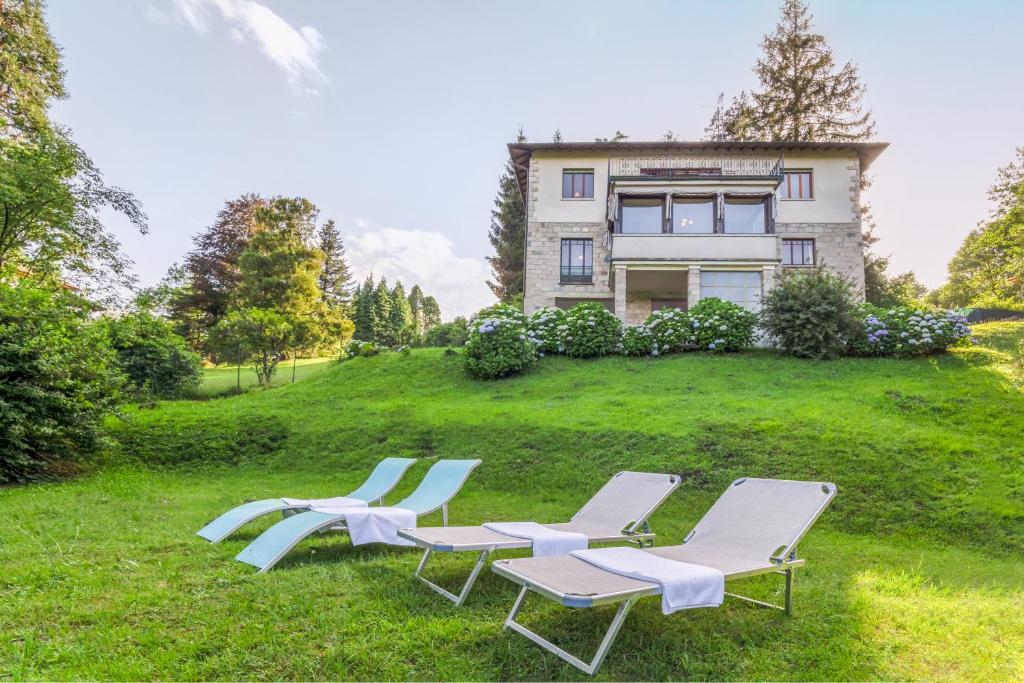 um grupo de cadeiras de jardim e uma casa em Villa Nelma by Casa da Suite em Gignese