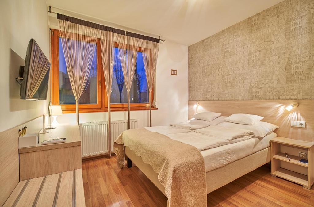 a bedroom with a large bed and a window at Oázis Apartmanok in Mórahalom