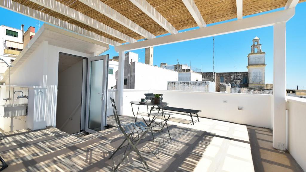 a balcony with a table and a view of a lighthouse at Les Maisons Casetta del Vico by Rentbeat in Sannicola