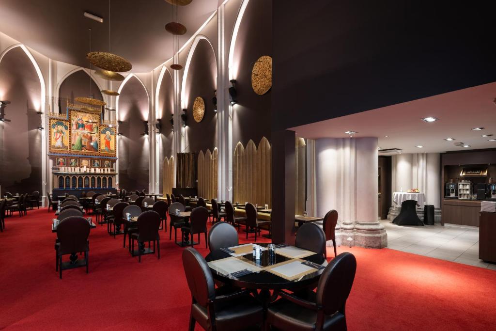 a restaurant with tables and chairs and a red carpet at Martin's Patershof in Mechelen