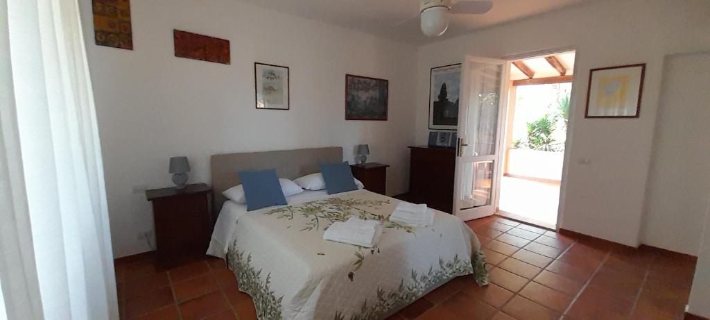 1 dormitorio con 1 cama y puerta abierta en Mirto E Mare, en Muravera