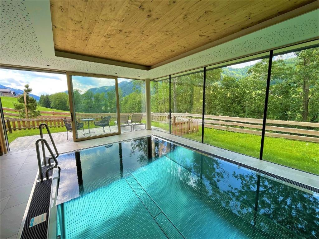a swimming pool in a house with windows at Chalets Schladming Ski-in Ski-out in Schladming
