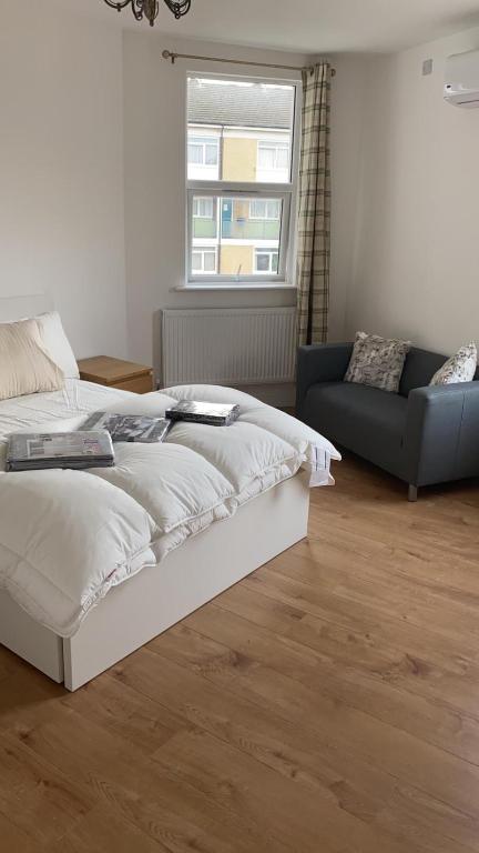 una camera con letto, divano e finestra di Newly refurbished flat in camberwell, london a Londra