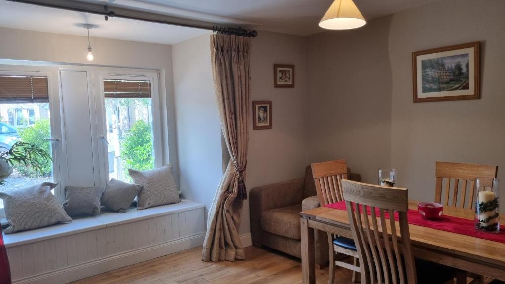 a dining room with a table and a window at 2 Bedroomed Ground Floor Apartment in Kenmare