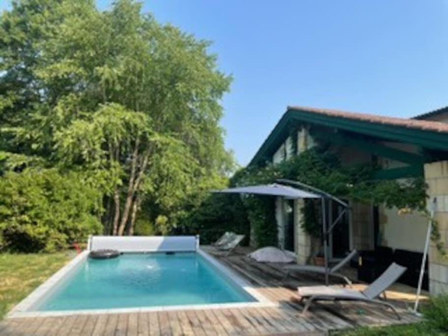 - une piscine en face d'une maison dans l'établissement Belle Villa basque avec piscine et jardin de 3000m2, à Saint-Jean-de-Luz