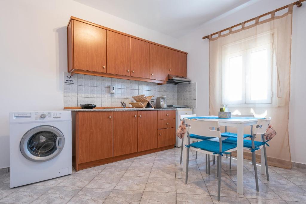 a kitchen with a table and a washing machine at A & K Vacation House in Varos