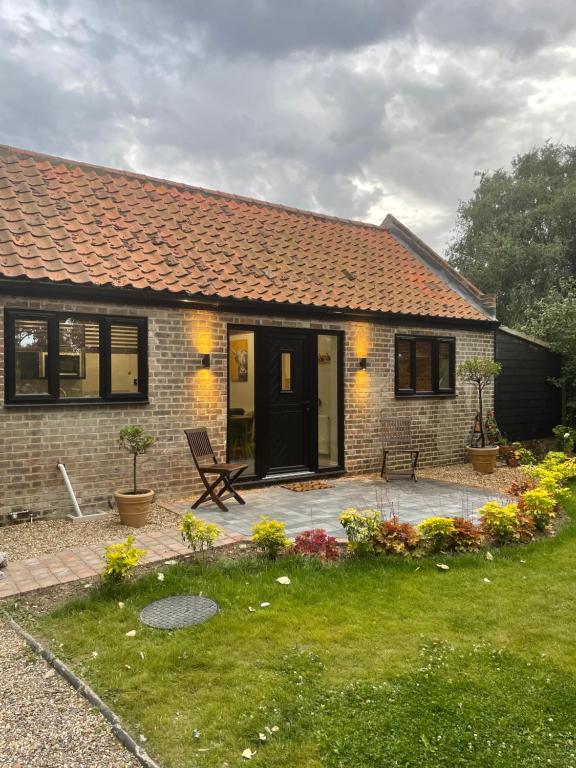 a small brick house with a patio in the yard at The Parlour in Great Yarmouth