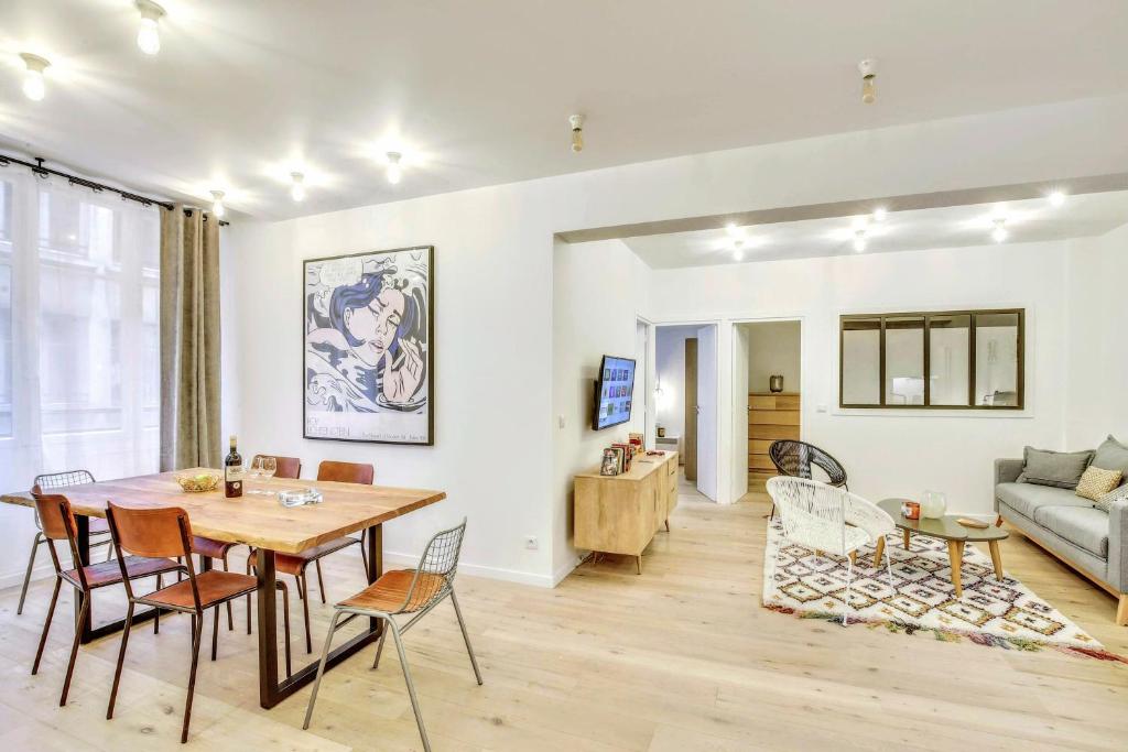 a dining room and living room with a table and chairs at Central & Stylish renovated Parisian apt / 6-8 guests in Paris