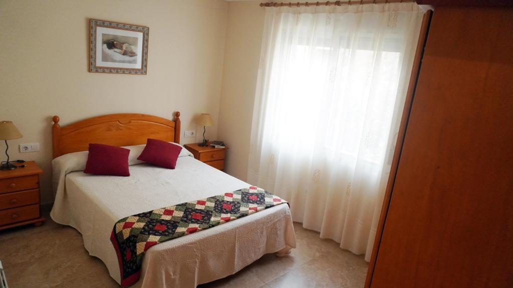 1 dormitorio con cama y ventana grande en Casa Manolita, en Albocácer