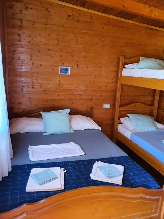 two bunk beds in a wooden cabin at Violet Village in Borsh
