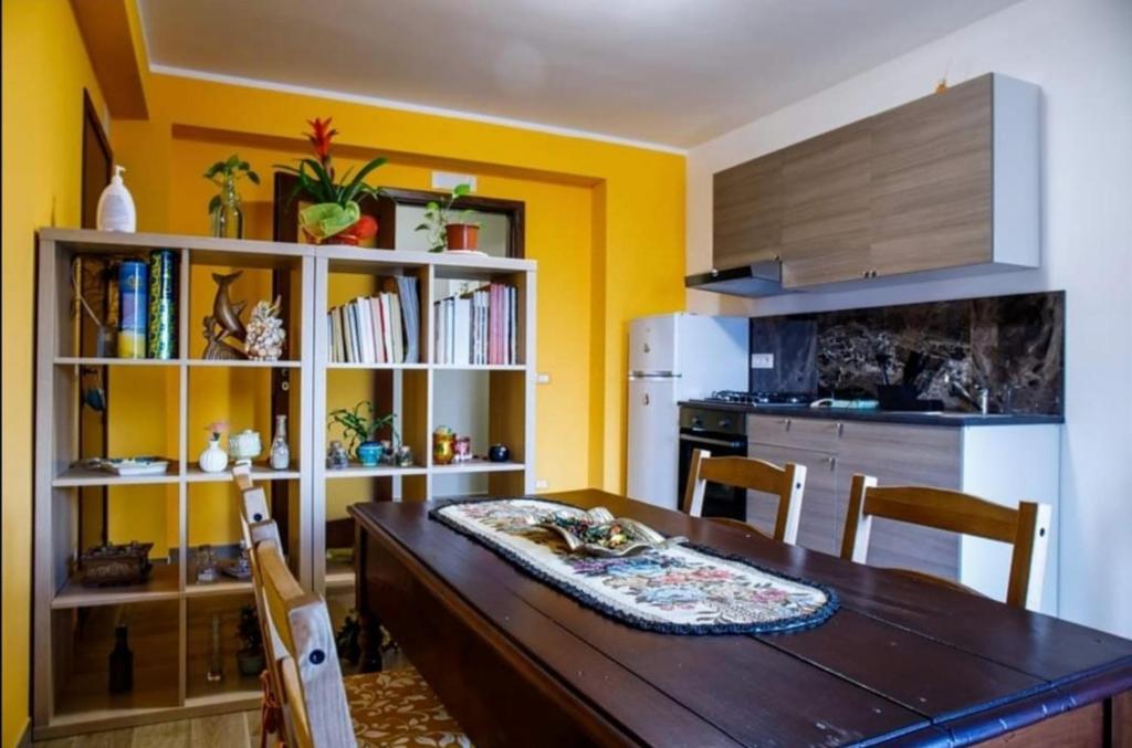 a kitchen with a wooden table and a kitchen with yellow walls at B&B Da Antonella in Troina