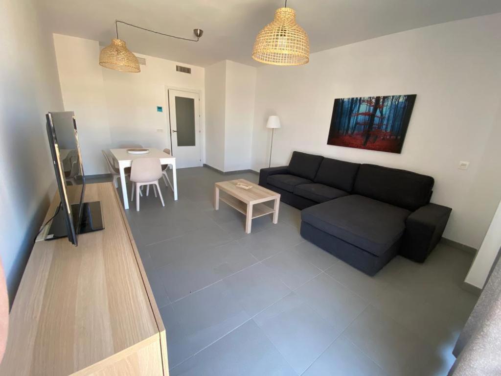 a living room with a couch and a table at piso recinto ferial en teatinos in Málaga