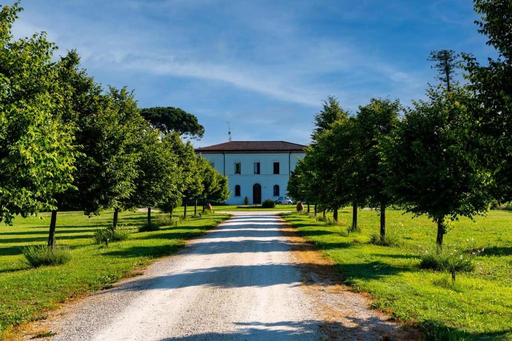 eine unbefestigte Straße vor einem weißen Gebäude in der Unterkunft Villa Archi in Faenza