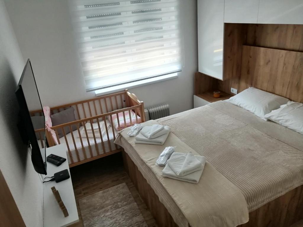 a small bedroom with a bed and a crib at Vuković Lux in Vrnjačka Banja