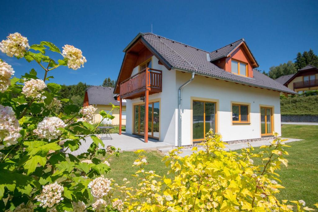 a house with a view of the yard at Villapark Lipno Dreams in Lipno nad Vltavou