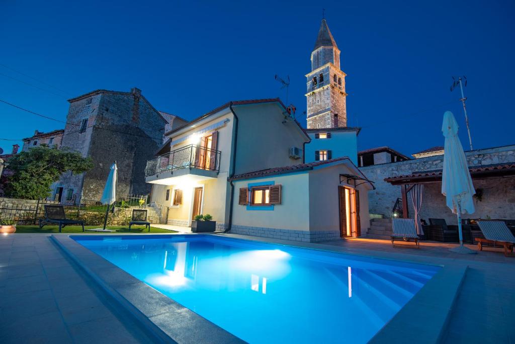 a villa with a swimming pool in front of a building at Stellar House Višnjan in Višnjan