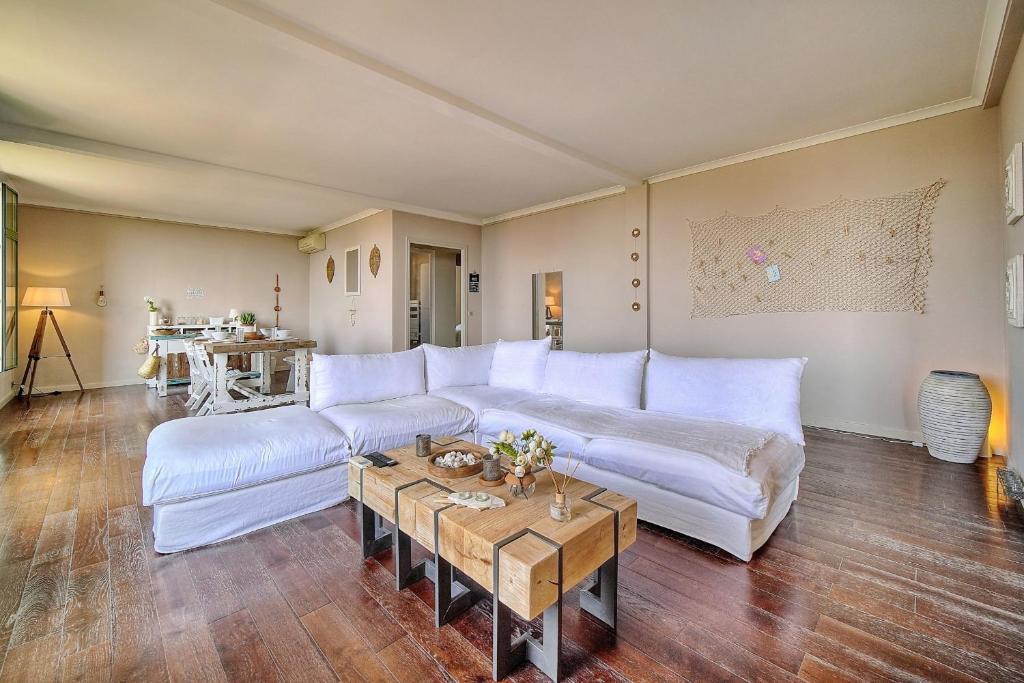 un salon avec un canapé blanc et une table dans l'établissement IMMOGROOM - Large Apartment - Parking - Air conditioning - Sea view - Wifi, à Cannes