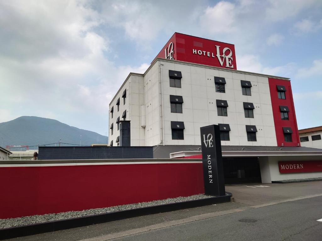 a hotel building with a sign in front of it at Hotel LOVE MODERN in Kitakyushu