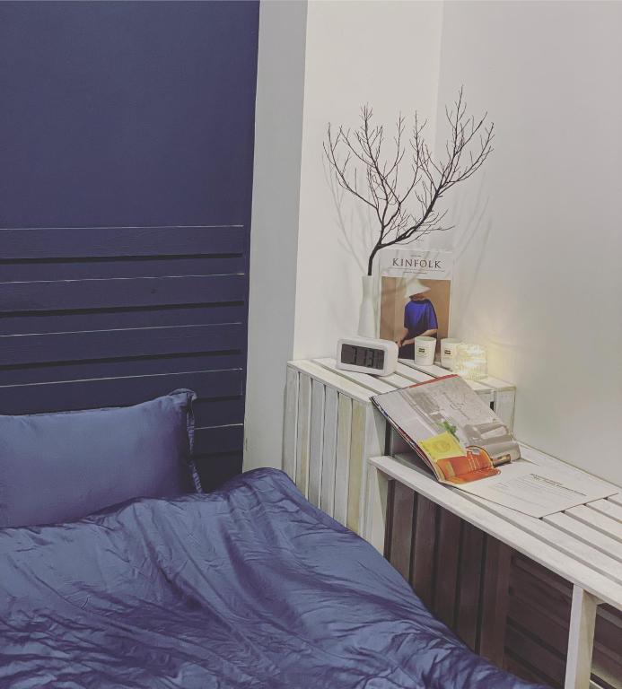 a bedroom with a bed and a table with a book at LILY HOUSE( Mini home 2PN) in Quy Nhon