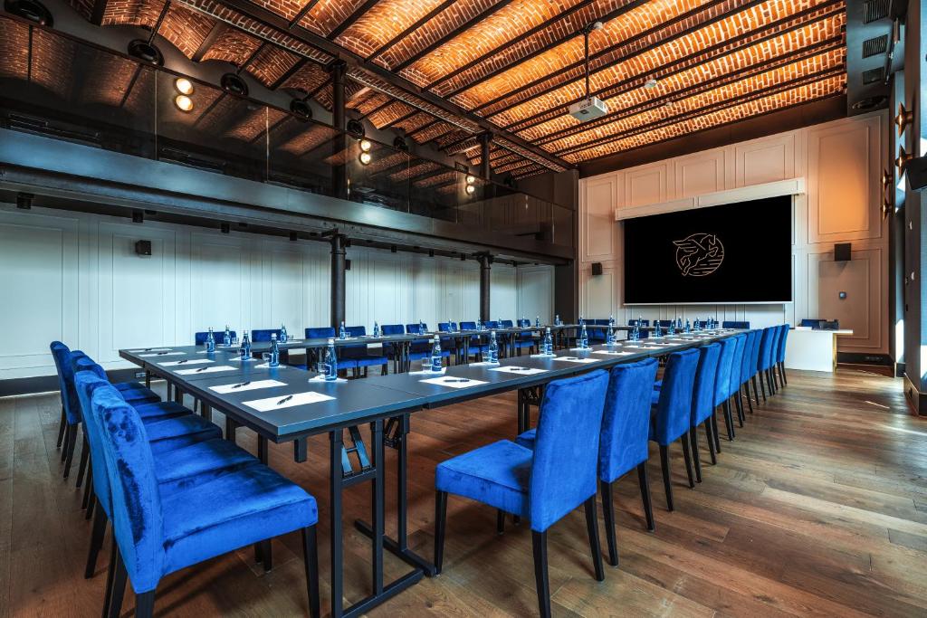 a large conference room with a long table and blue chairs at Hotel Ferreus Modern Art Deco in Krakow