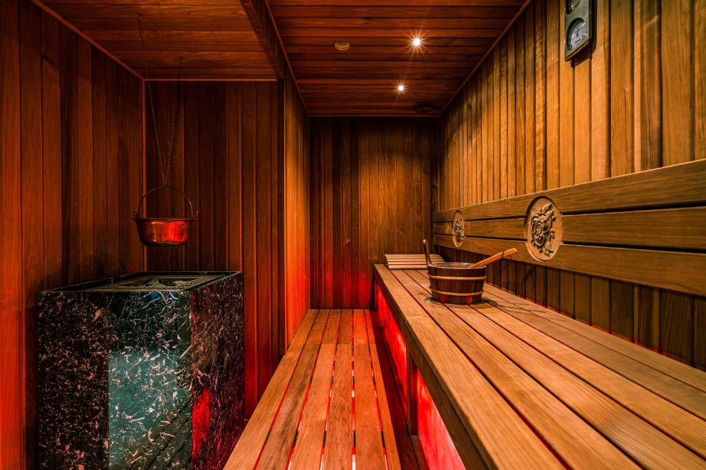 a sauna with a wooden floor and a wooden bench at Hotel Ferreus Modern Art Deco in Krakow