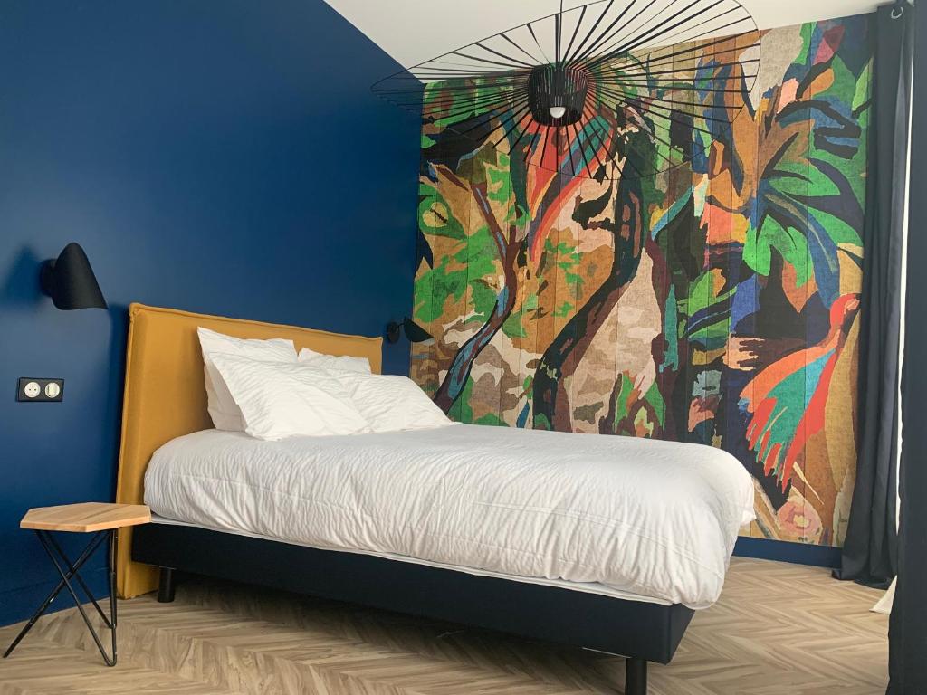 1 dormitorio con 1 cama con una pintura en la pared en Pau's Appart - Pau Centre, en Pau