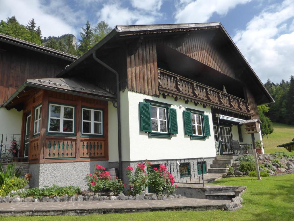 una casa con techo de gambas y persianas verdes en Haus Hütter en Altaussee