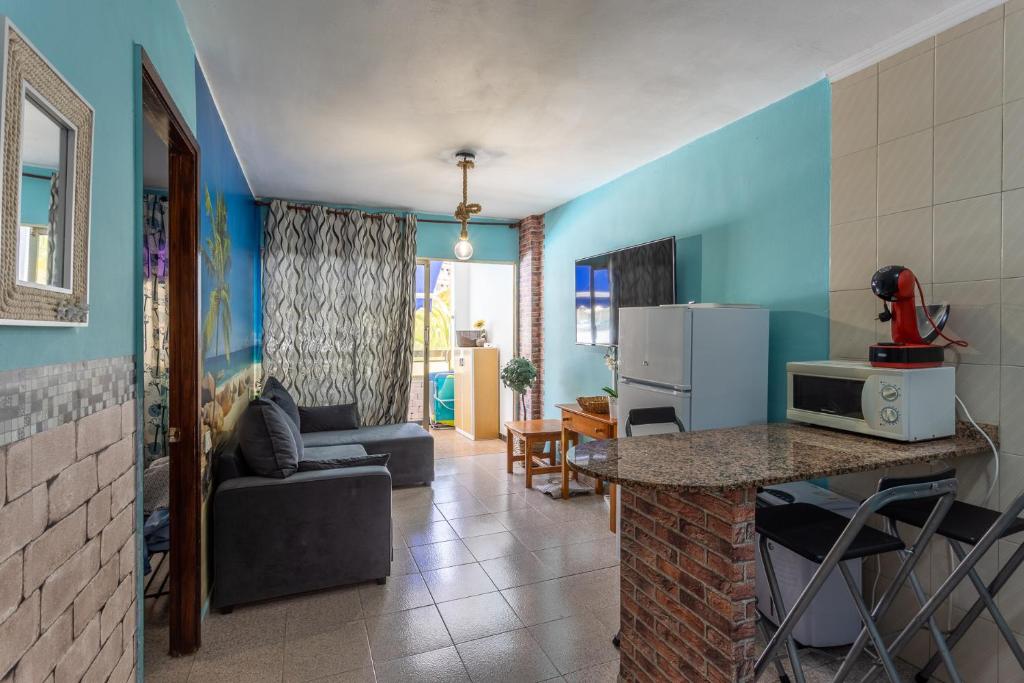 kuchnia i salon z kanapą i stołem w obiekcie Tinache Beach 103 Maspalomas w mieście San Bartolomé