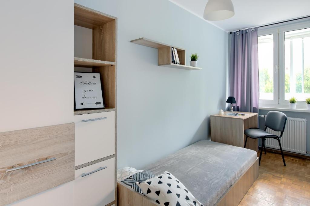 a small bedroom with a bed and a desk at SuperApart Krzywoń 8 ROOMS in Warsaw