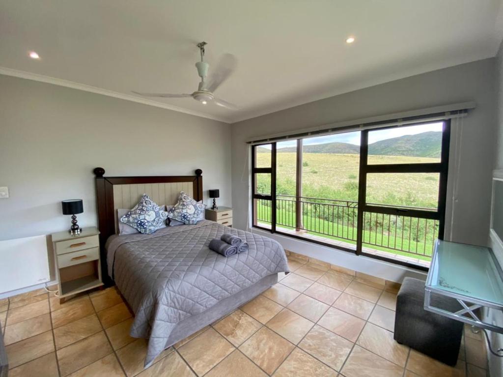 1 dormitorio con cama y ventana grande en Odendaal's Ridge, en Clarens