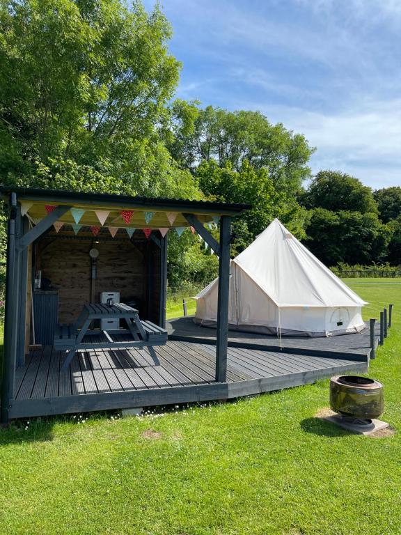 a gazebo and a tent on a field at Bell tent 1 Glyncoch isaf farm in Llwyn-Dafydd