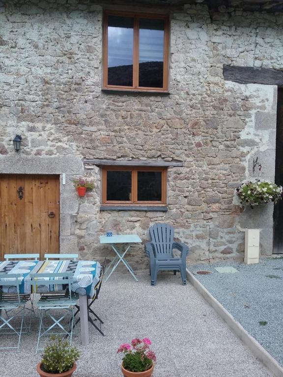 a patio with a table and chairs and a building at Lake view in Cieux