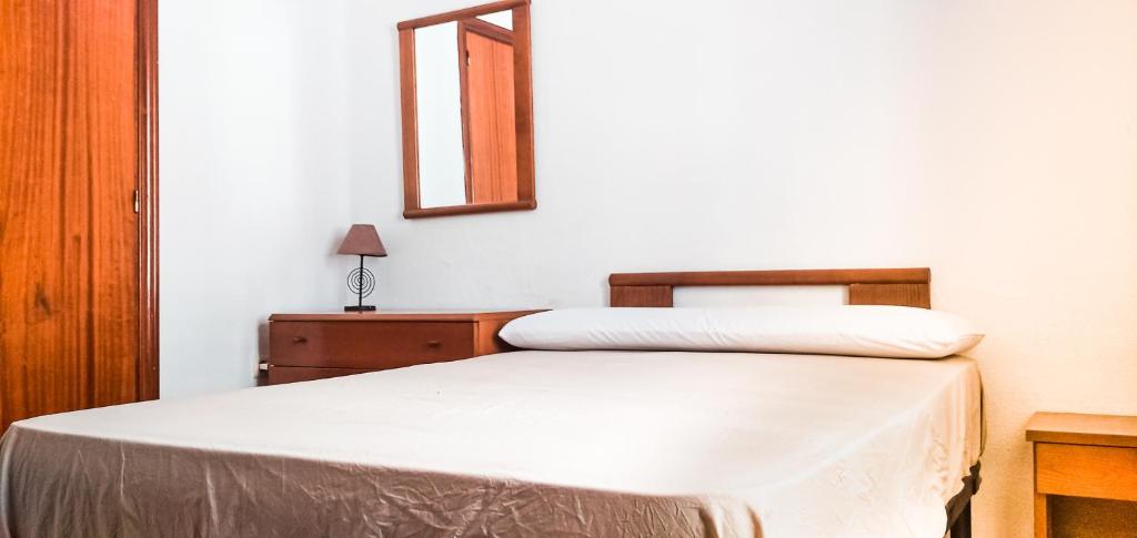 sypialnia z łóżkiem z lustrem i komodą w obiekcie Sweet Room in Malaga Center "Homestay" - Habitación Alojamiento en Apartamento w Maladze