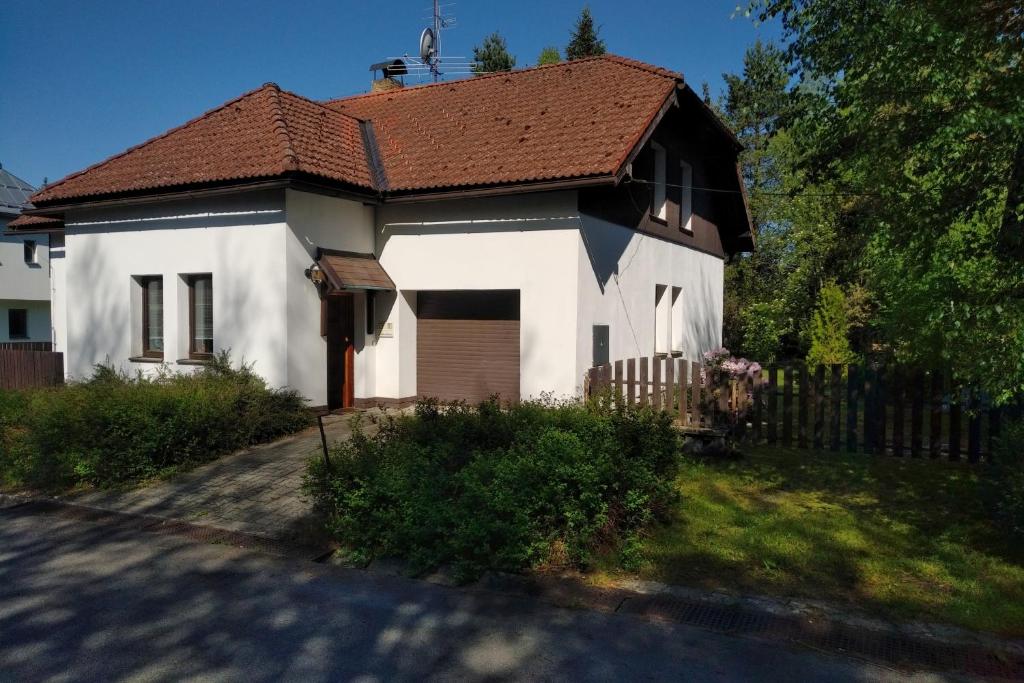 a white house with a brown roof at Cottage House in Stožec